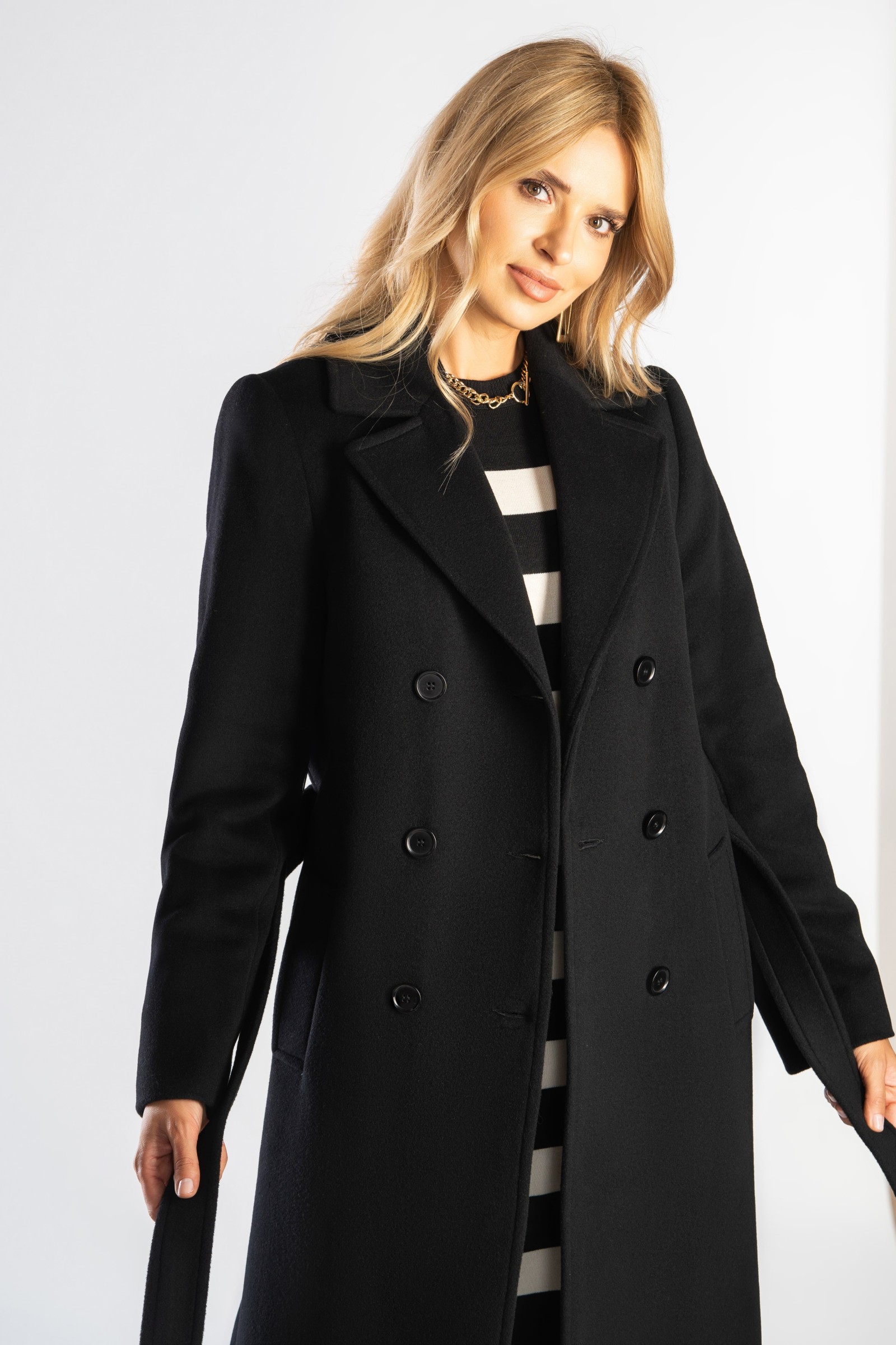 Ponadczasowy, długi płaszcz z paskiem wiązanym w talii.
Zimowy, dwurzędowy damski trencz.