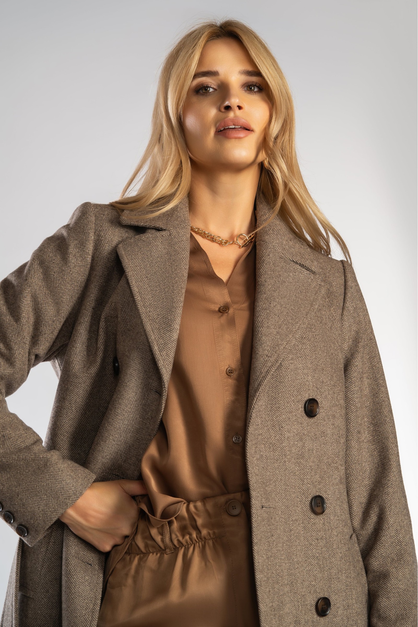 Ponadczasowy, długi płaszcz z paskiem wiązanym w talii.
Zimowy, dwurzędowy damski trencz.