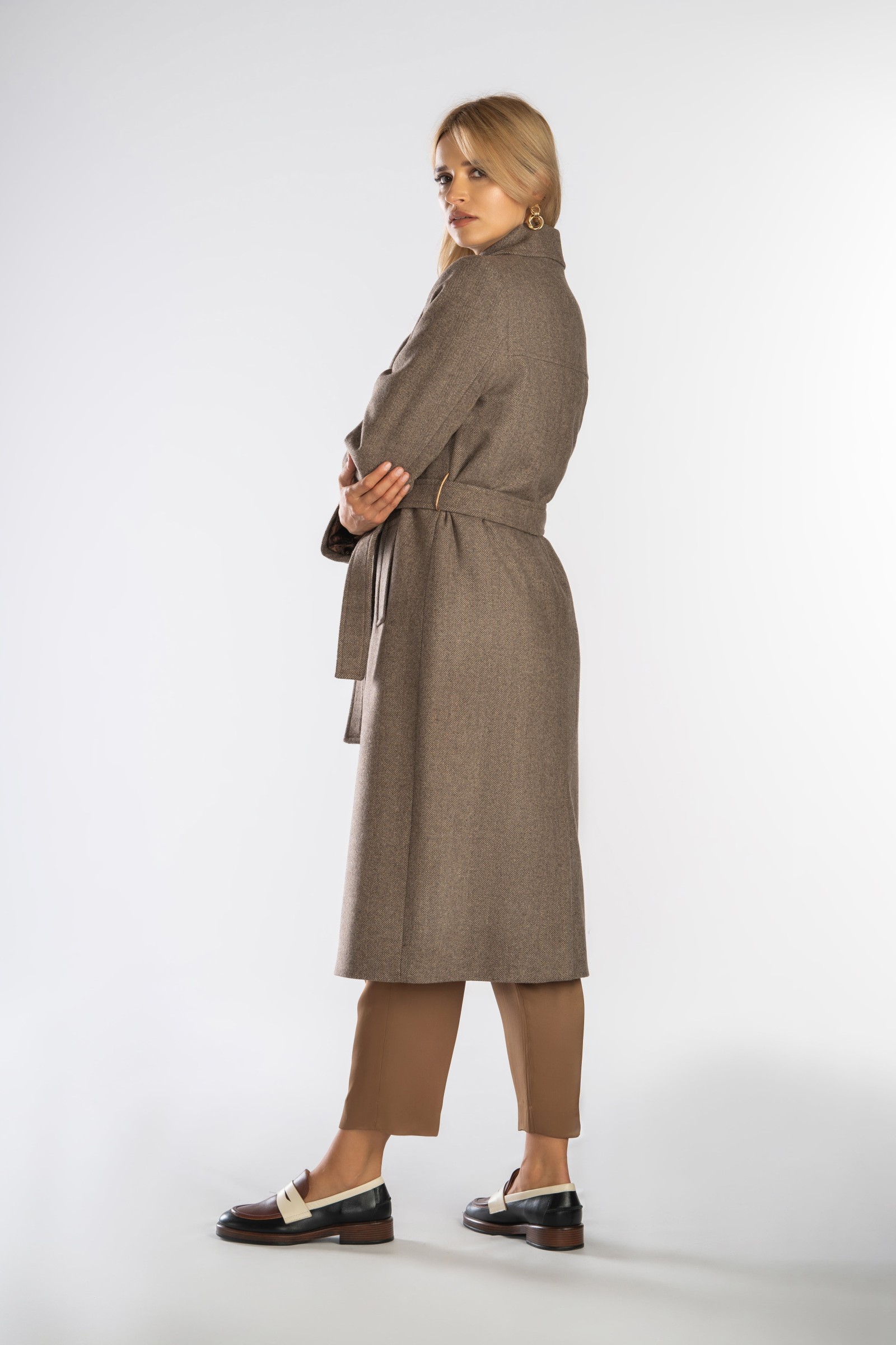 Ponadczasowy, długi płaszcz z paskiem wiązanym w talii.
Zimowy, dwurzędowy damski trencz.