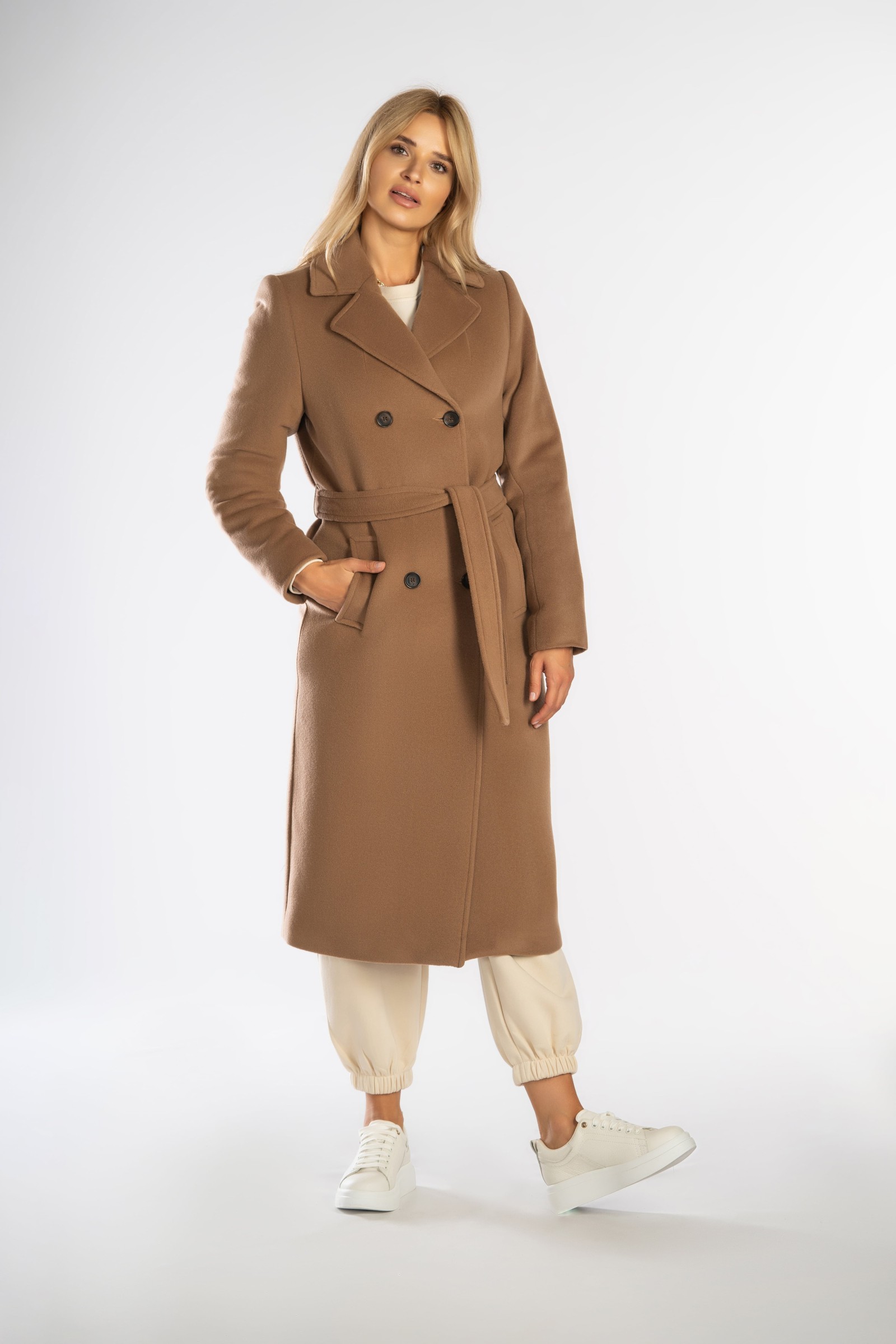 Ponadczasowy, długi płaszcz z paskiem wiązanym w talii.
Zimowy, dwurzędowy damski trencz.