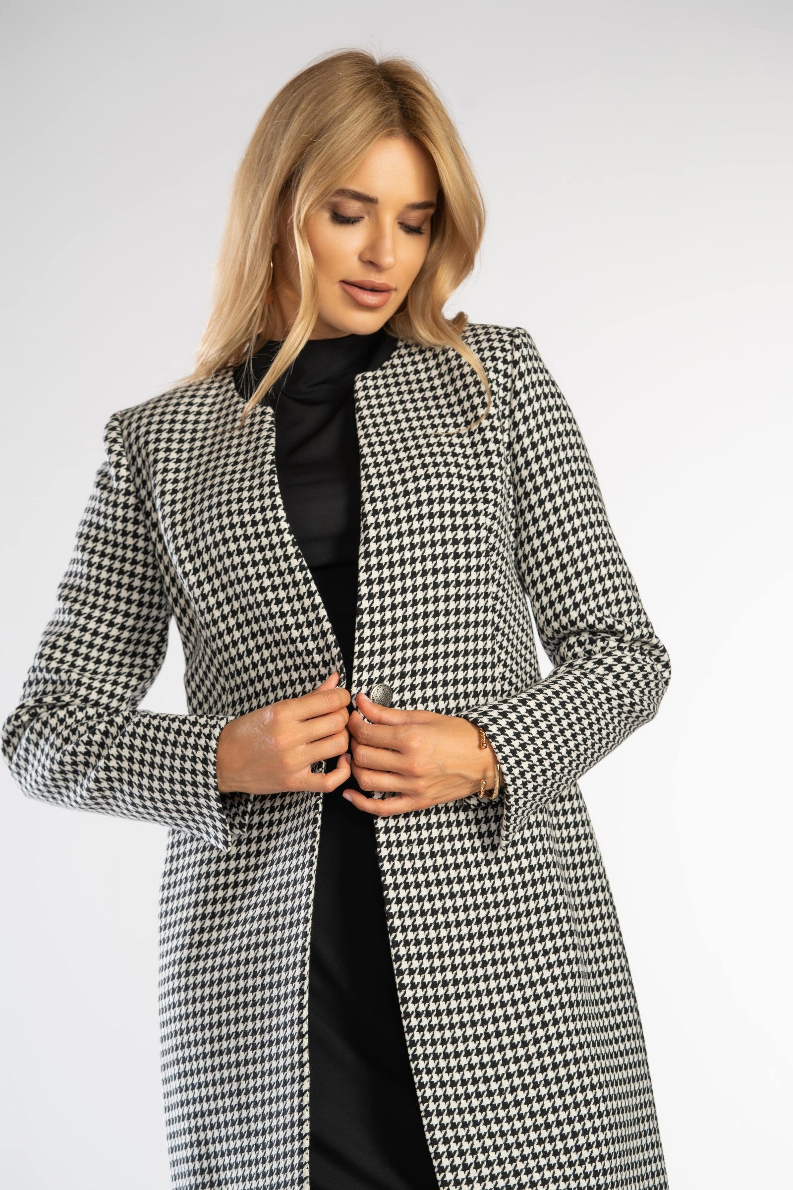 Prosty, elegancki płaszcz zapinany na guzik w talii.