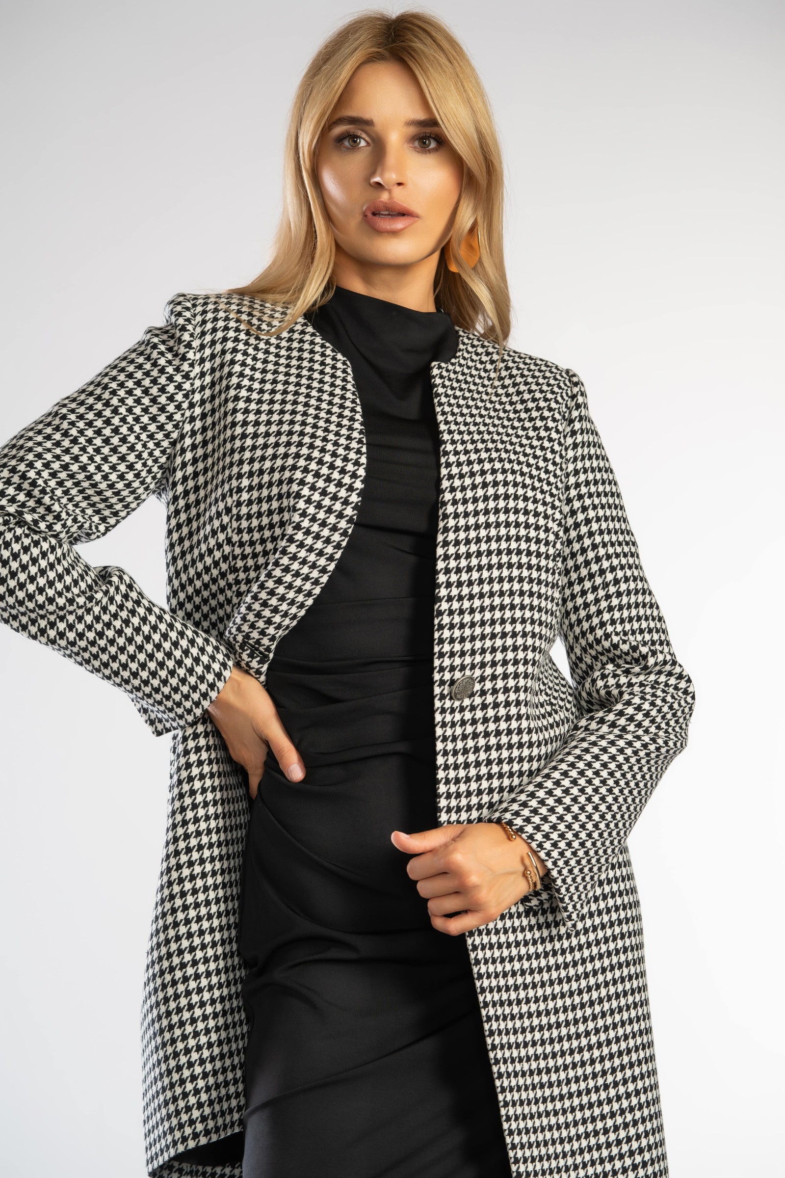 Prosty, elegancki płaszcz zapinany na guzik w talii.