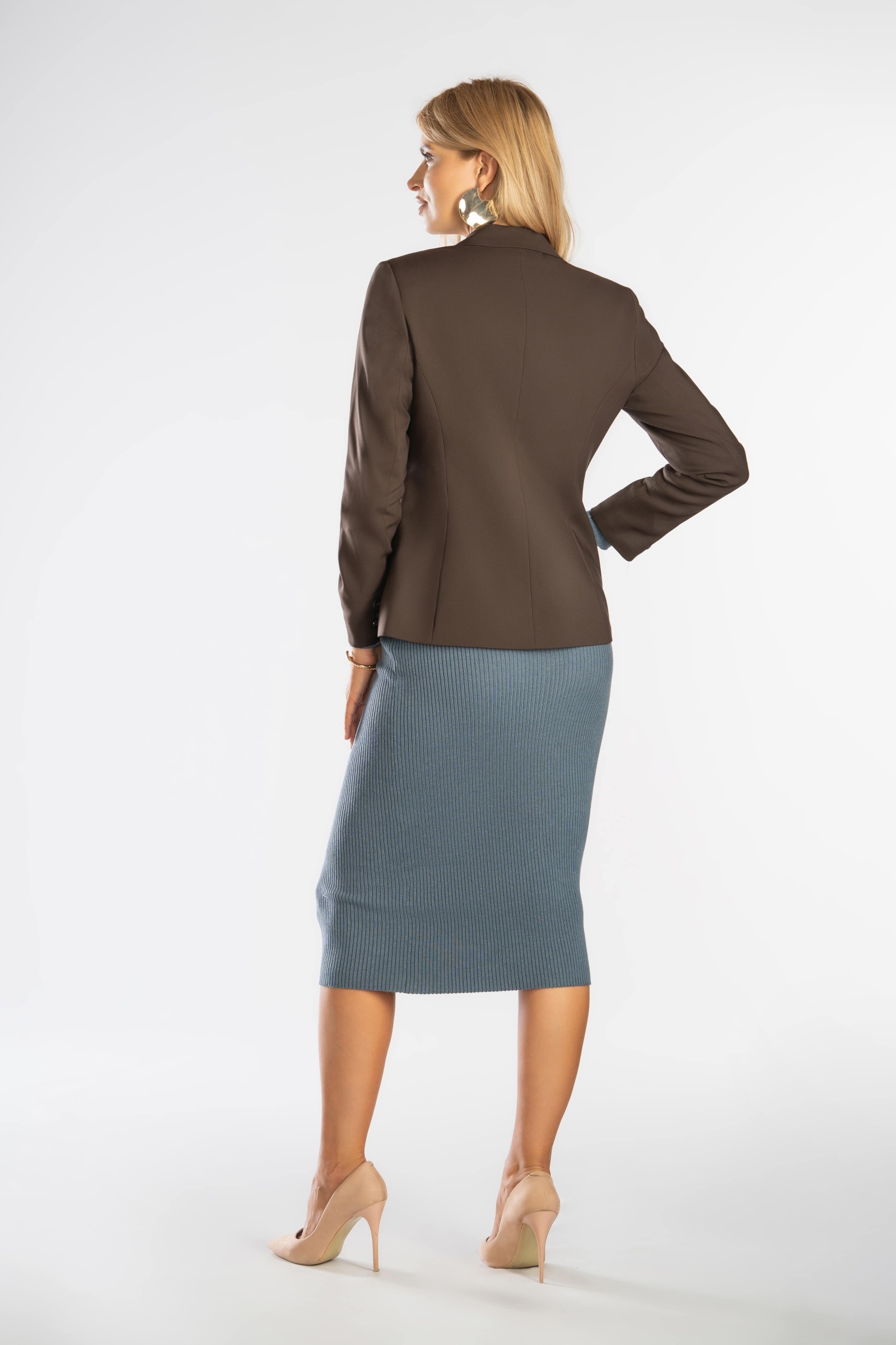 Delikatnie taliowany, klasyczny żakiet zapinany na guziki.