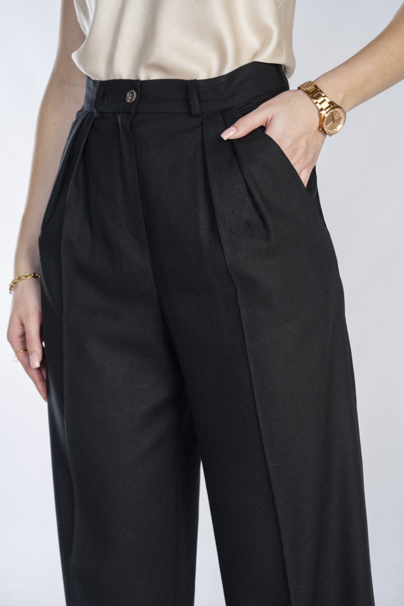 Klasyczne, czarne, eleganckie spodnie z prostą nogawką i zakładkami.