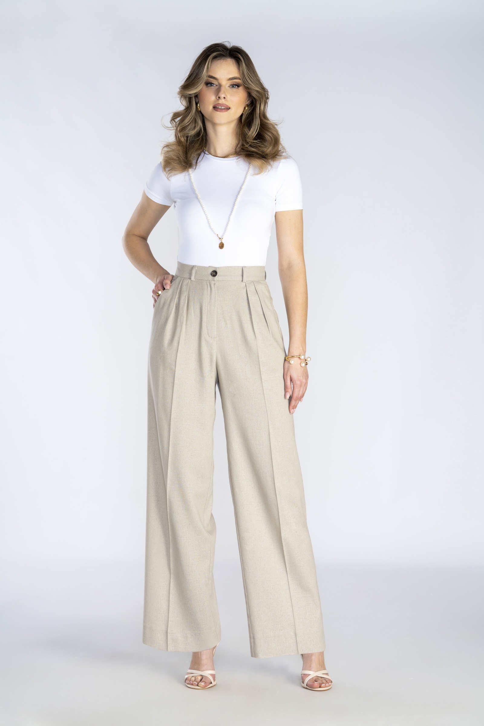 Klasyczne, beżowe, eleganckie spodnie z prostą nogawką i zakładkami.