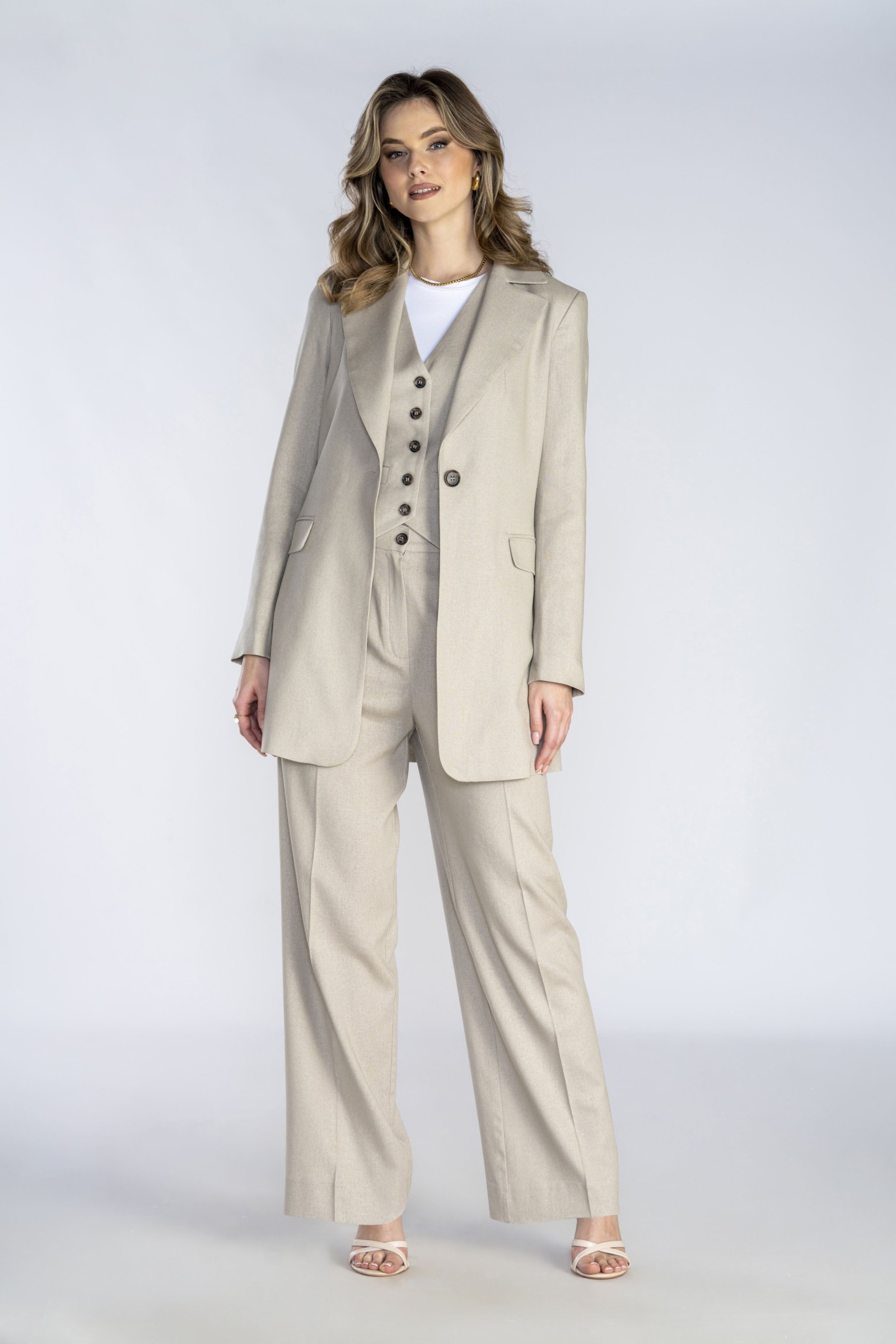 Długa beżowa marynarka wykonana z naturalnej tkaniny.